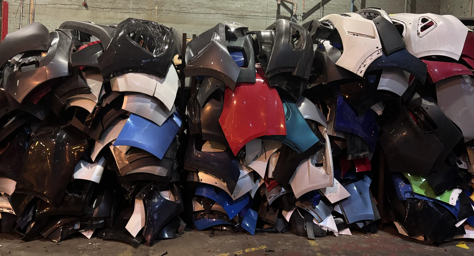 Loose damaged car bumpers stacked for collection and recycling